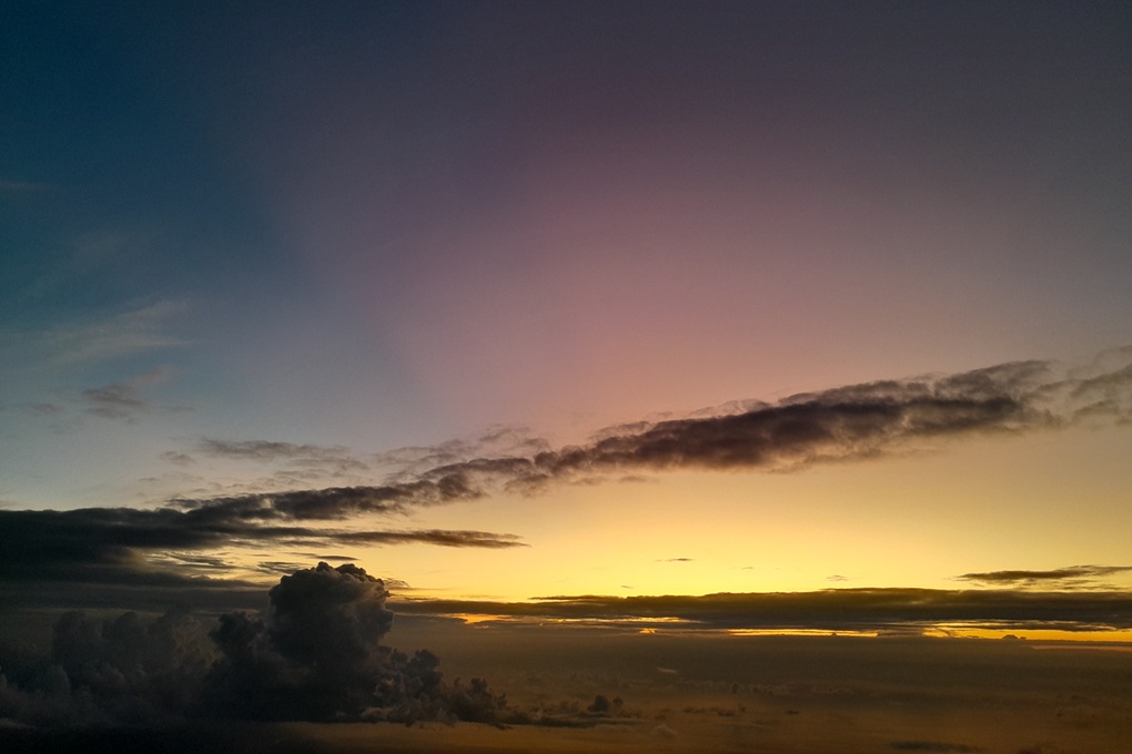 coucher de soleil subtil à La Réunion, avec un ciel dégradé jaune et violet et des nuages étirés à l’horizon