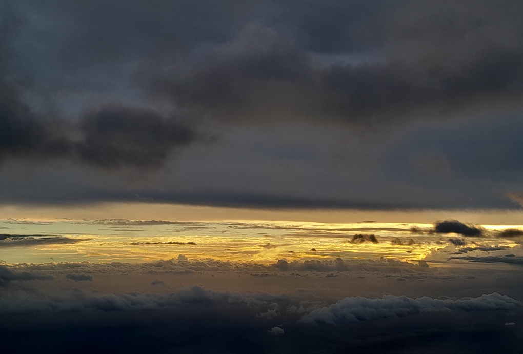 coucher de soleil sombre à La Réunion, avec des nuages épais et une lumière dorée filtrée à l’horizon