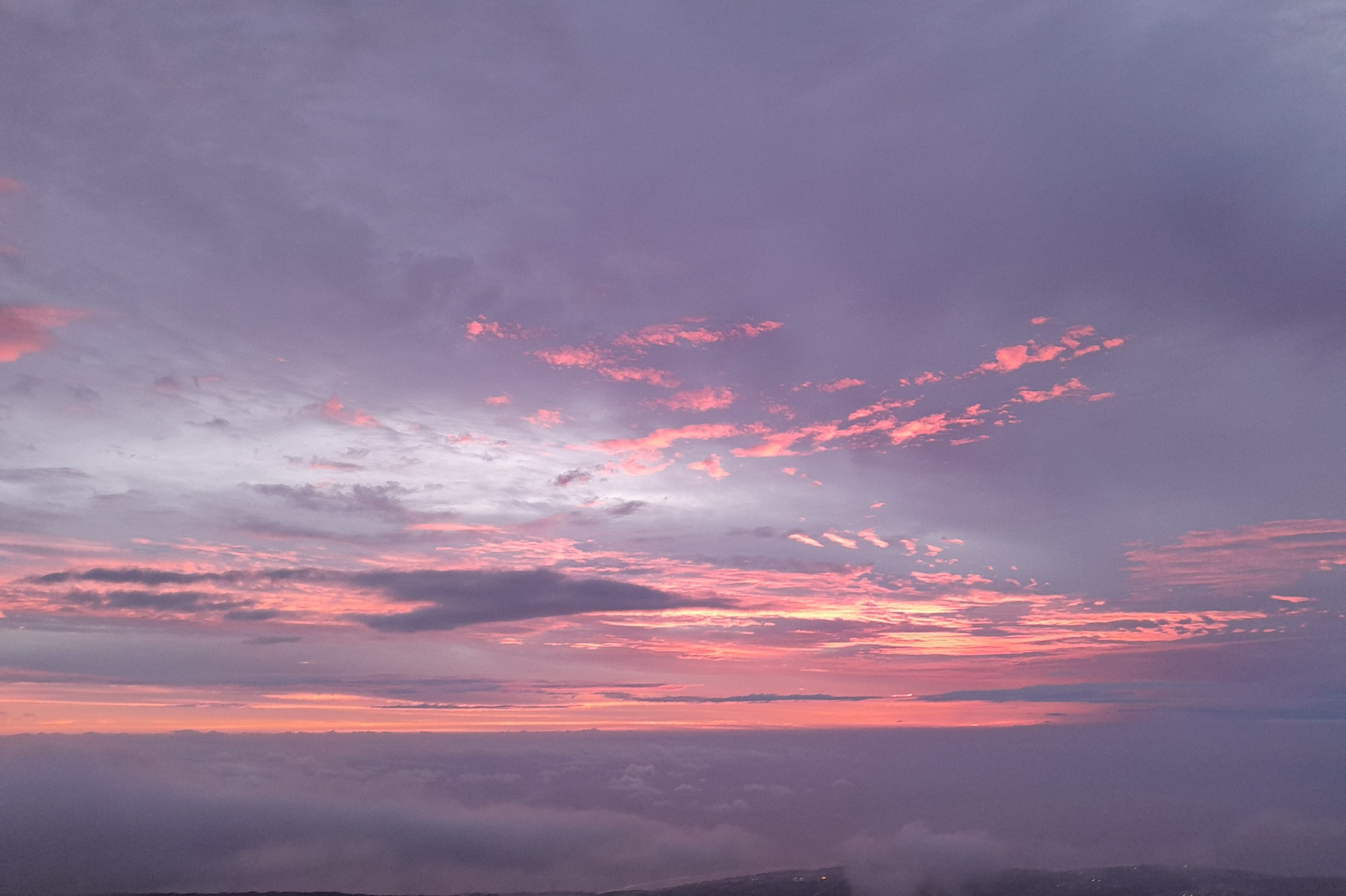 coucher de soleil sombre à La Réunion, avec des nuages épais et une lumière dorée filtrée à l’horizon