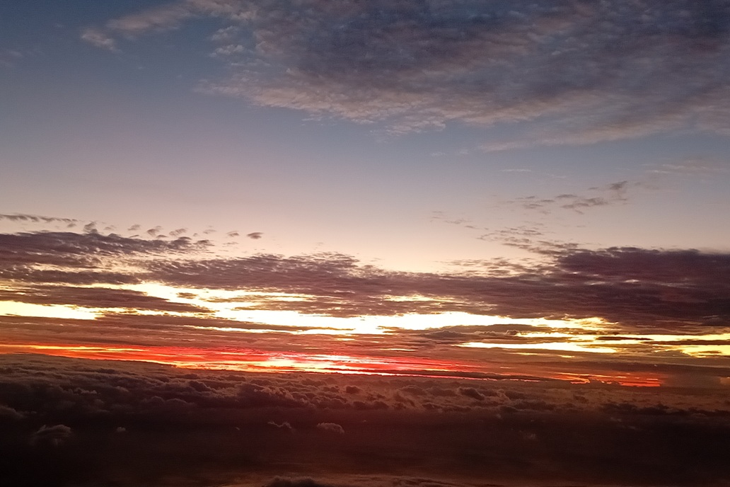 coucher de soleil intense à La Réunion, avec un ciel rouge profond et des nuages sombres à l’horizon
