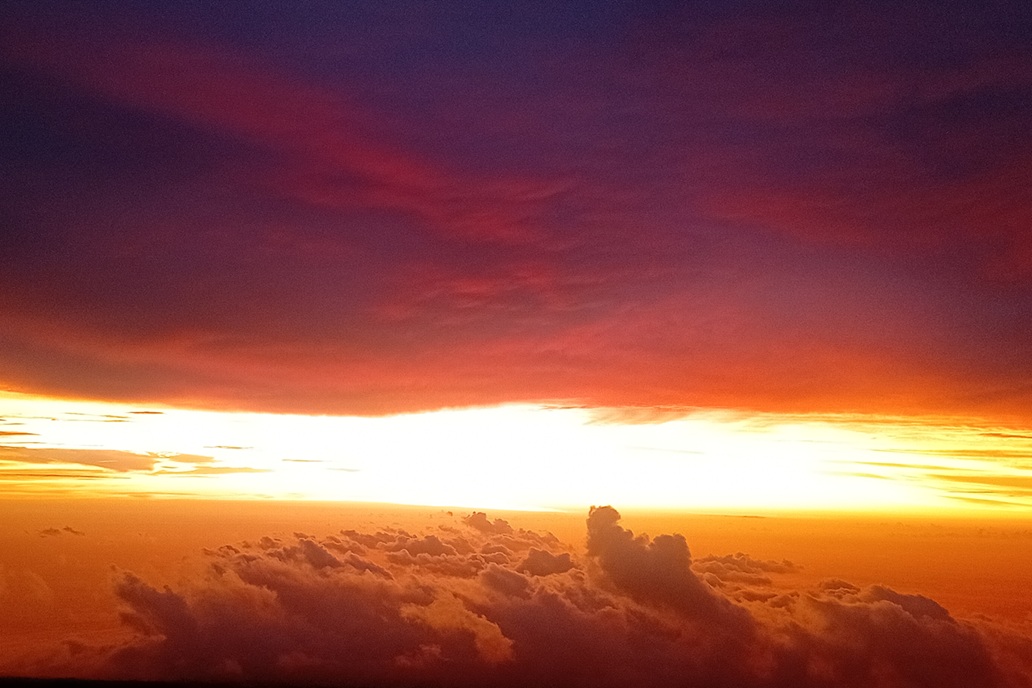 coucher de soleil sombre à La Réunion, avec des nuages épais et une lumière dorée filtrée à l’horizon