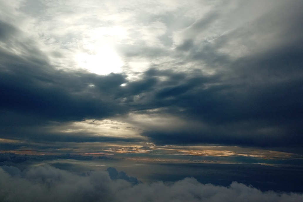 coucher de soleil dramatique à La Réunion, avec des nuages sombres et une lumière perçant le ciel au-dessus de l’océan