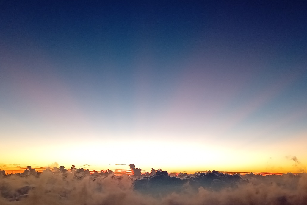 coucher de soleil apaisant à La Réunion, avec un ciel clair et une lumière douce au-dessus d’une mer de nuages calme