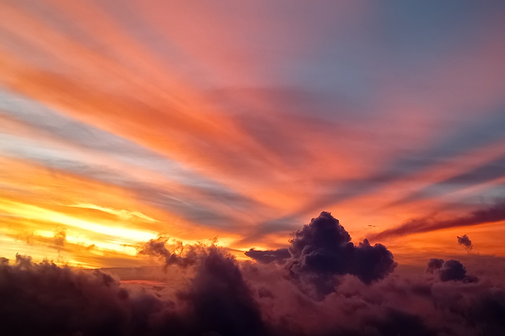 coucher de soleil artistique à La Réunion, avec des nuages violets et orange et un ciel lumineux au-dessus des nuages